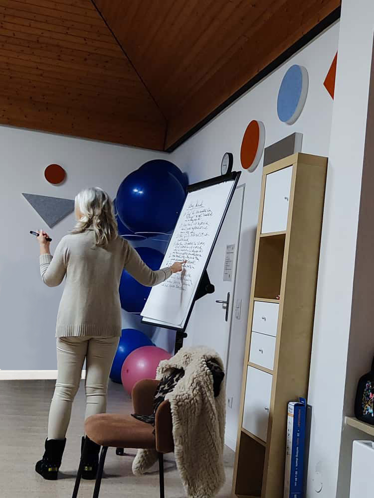 Frau Ulrike Vinmann präsentiert an einem Flipchart beim Seminar Reinkarnationstherapie
